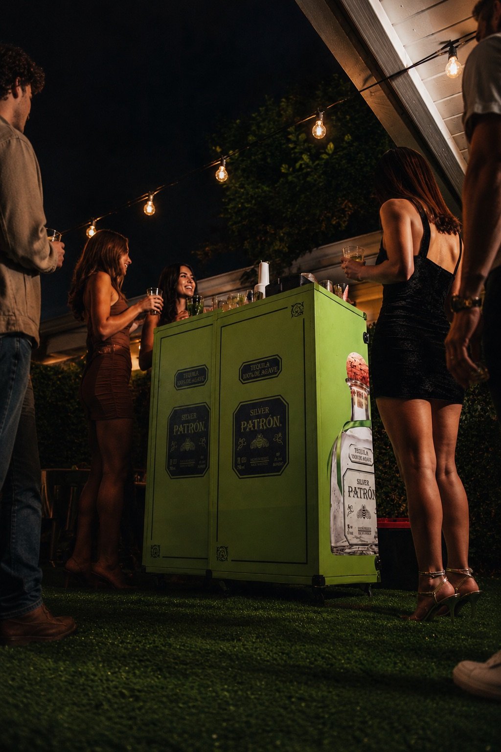 Guests gathered around the Patrón bar at night